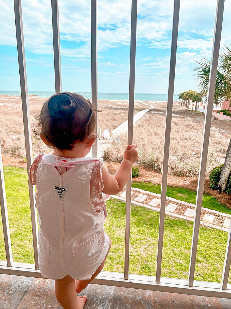 toddler on balcony looking at gulf