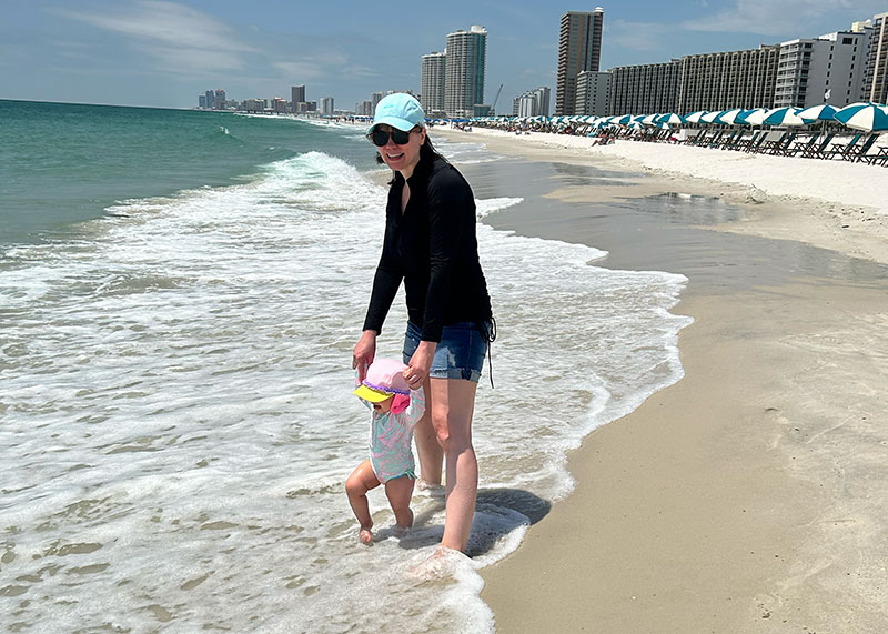 mom and toddler in waves at beach