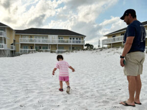 Child and father in front of Sandpiper Cove Condo in Destin