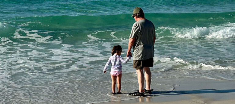 Child and grandparent on beach in Destin, Florida